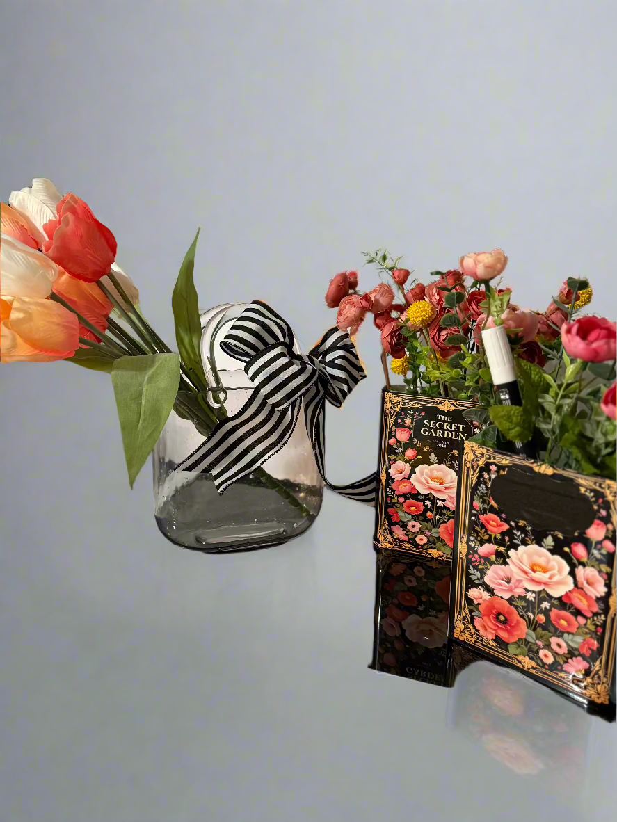 The Secret Garden decorative book vases collection with elegant gold frame detailing and black floral design, paired with artificial coral roses and yellow accent flowers