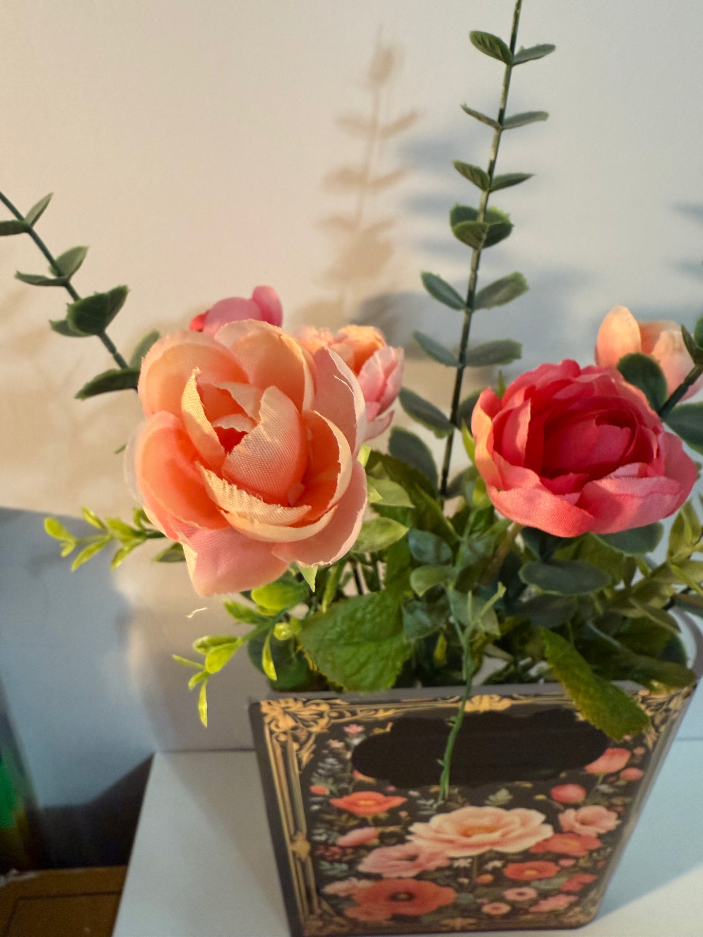 The Secret Garden decorative book vases collection with elegant gold frame detailing and black floral design, paired with artificial coral roses and yellow accent flowers