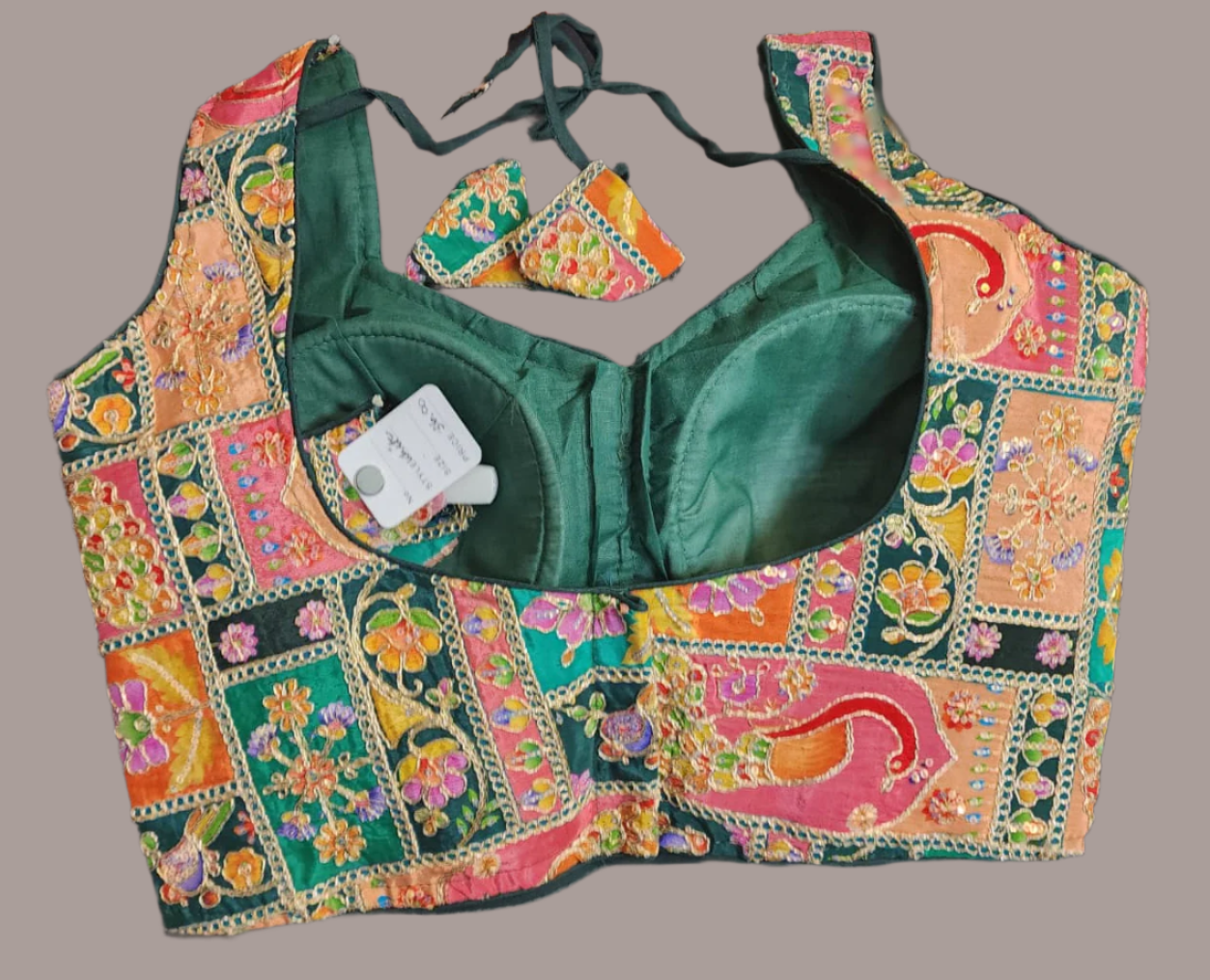 Green blouse with colorful floral patterns on a gray background