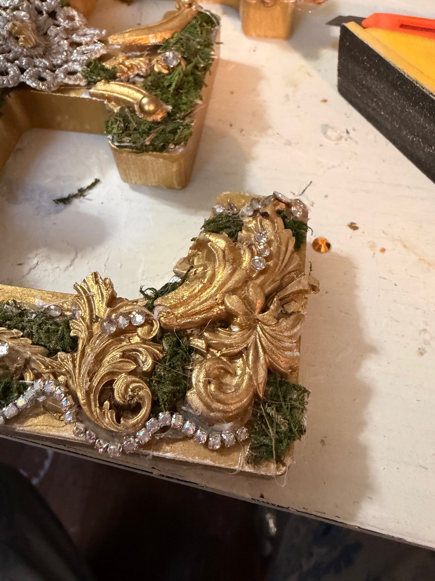 Decorative gilded hand made with greenery on a workbench