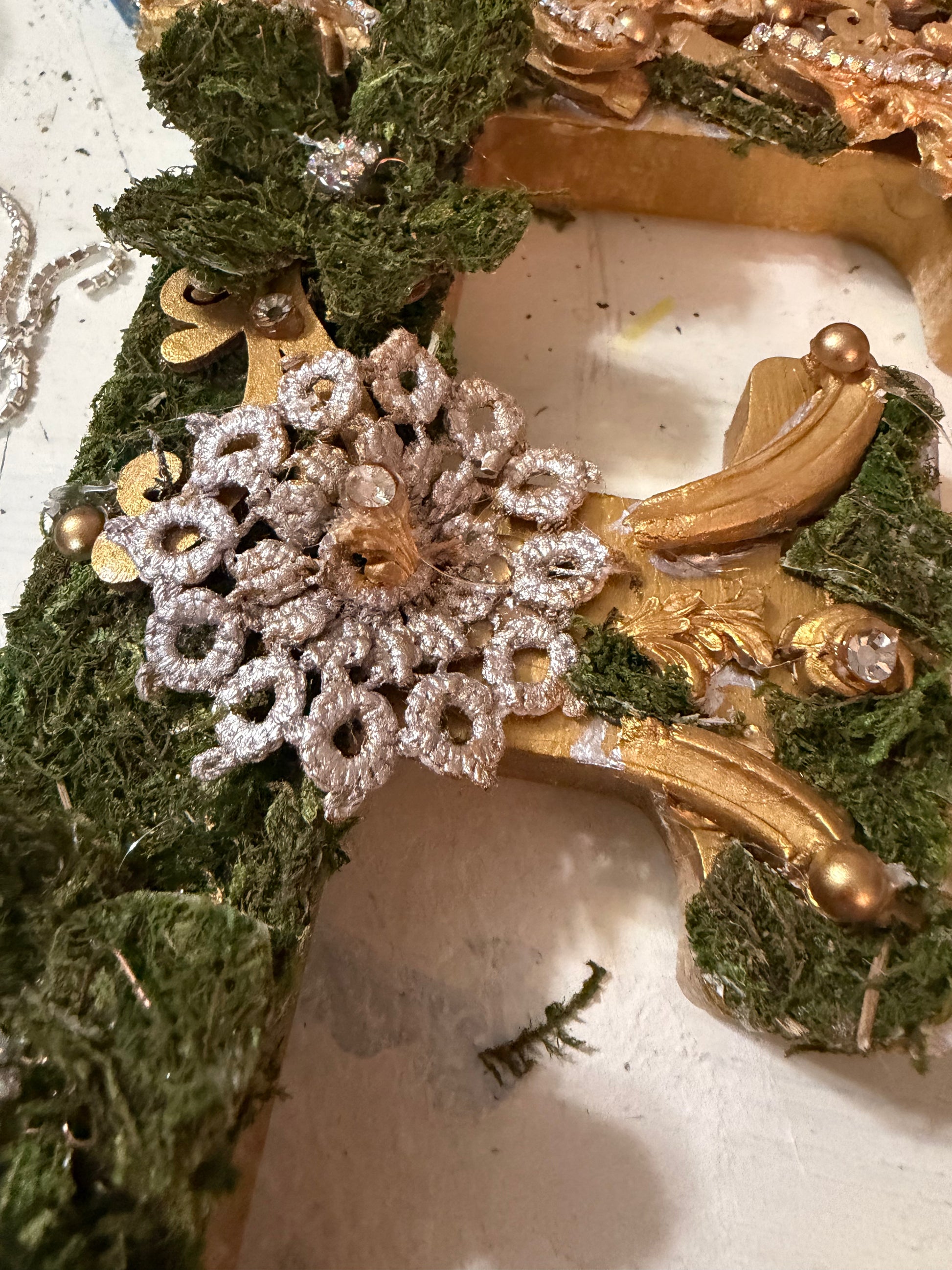 Decorative Letter with gold and silver wood and floral design on a white background